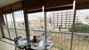 En balkon med et bord til fire, der vender ud over et boligområde med flere lejlighedskomplekser.
