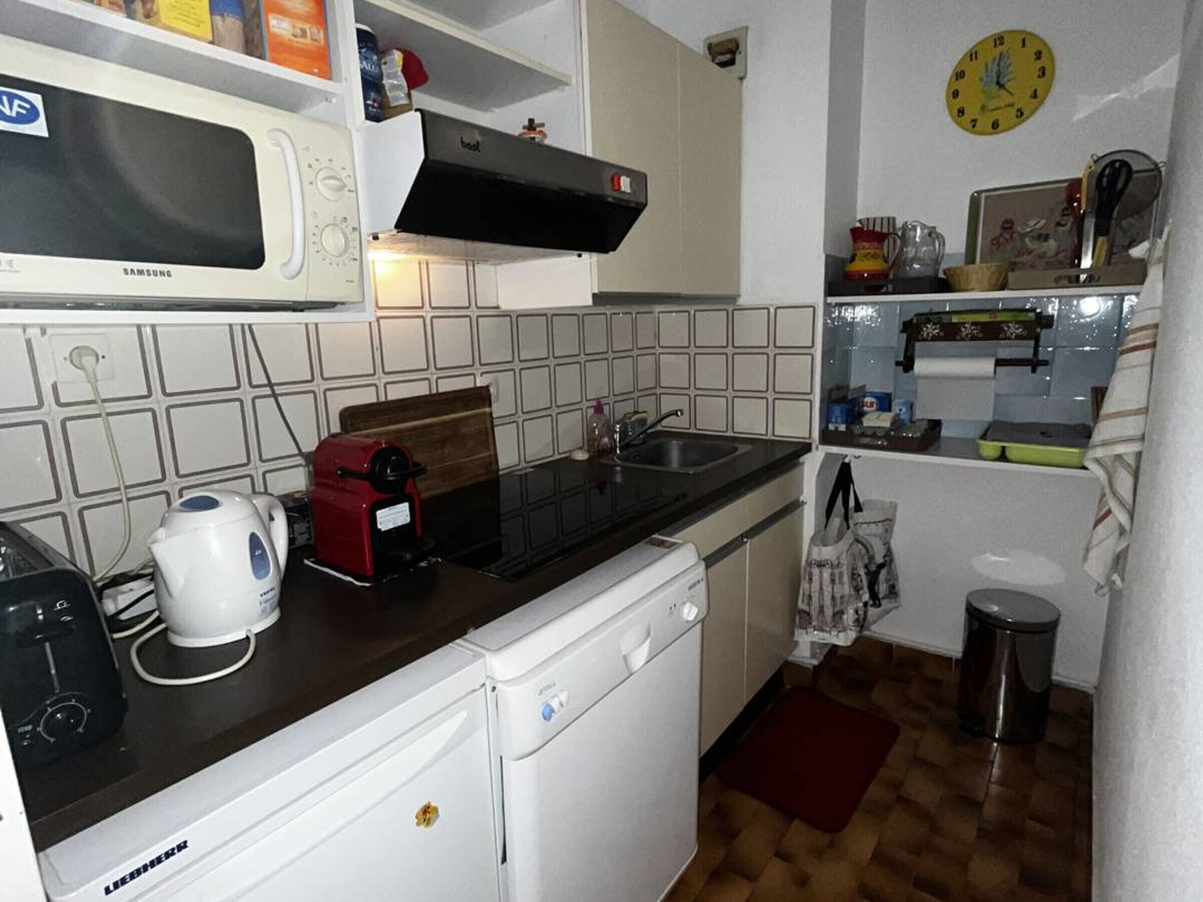 A compact kitchen with a microwave, toaster, and sink.