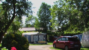 A campsite with a tented area, a red car, and a caravan. - 30m² Chalet with Terrace for 6 People (Capvern)