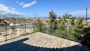 Un balcón con vista a la playa y al paisaje urbano.