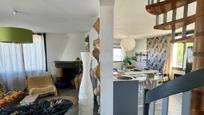 Una sala de estar moderna con chimenea, un comedor y una escalera.