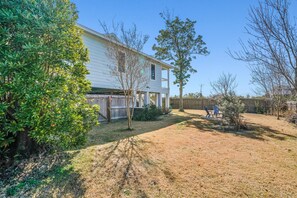 A house with a covered porch, a fenced yard, and a small tree in the foreground. - Mexico Beach w/Low Speed Vehicle (Mexico Beach)
