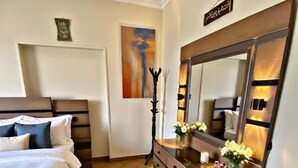 Una habitación de hotel con una cama, un aparador, un espejo y un cuadro en la pared.