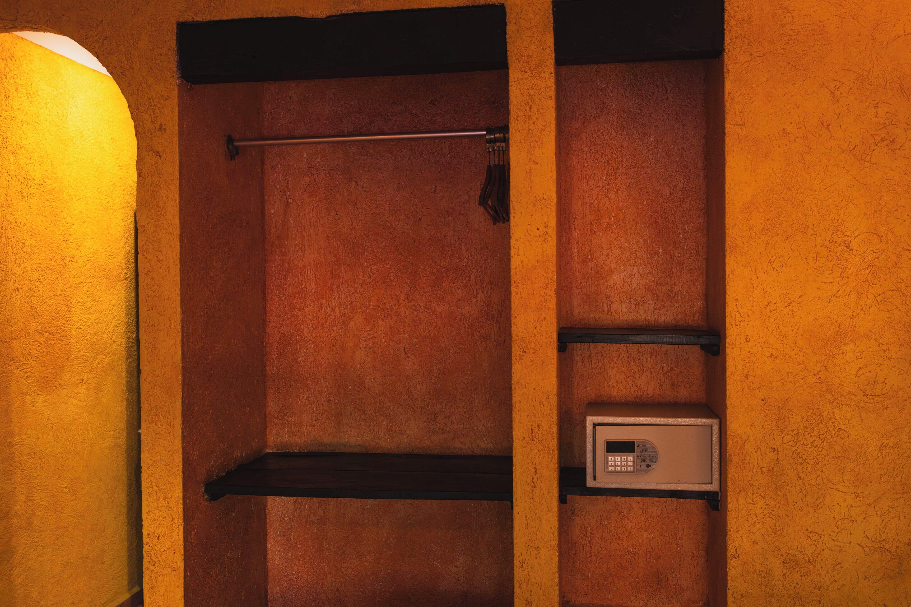 A room with a wooden door, a towel rack, and a security keypad.