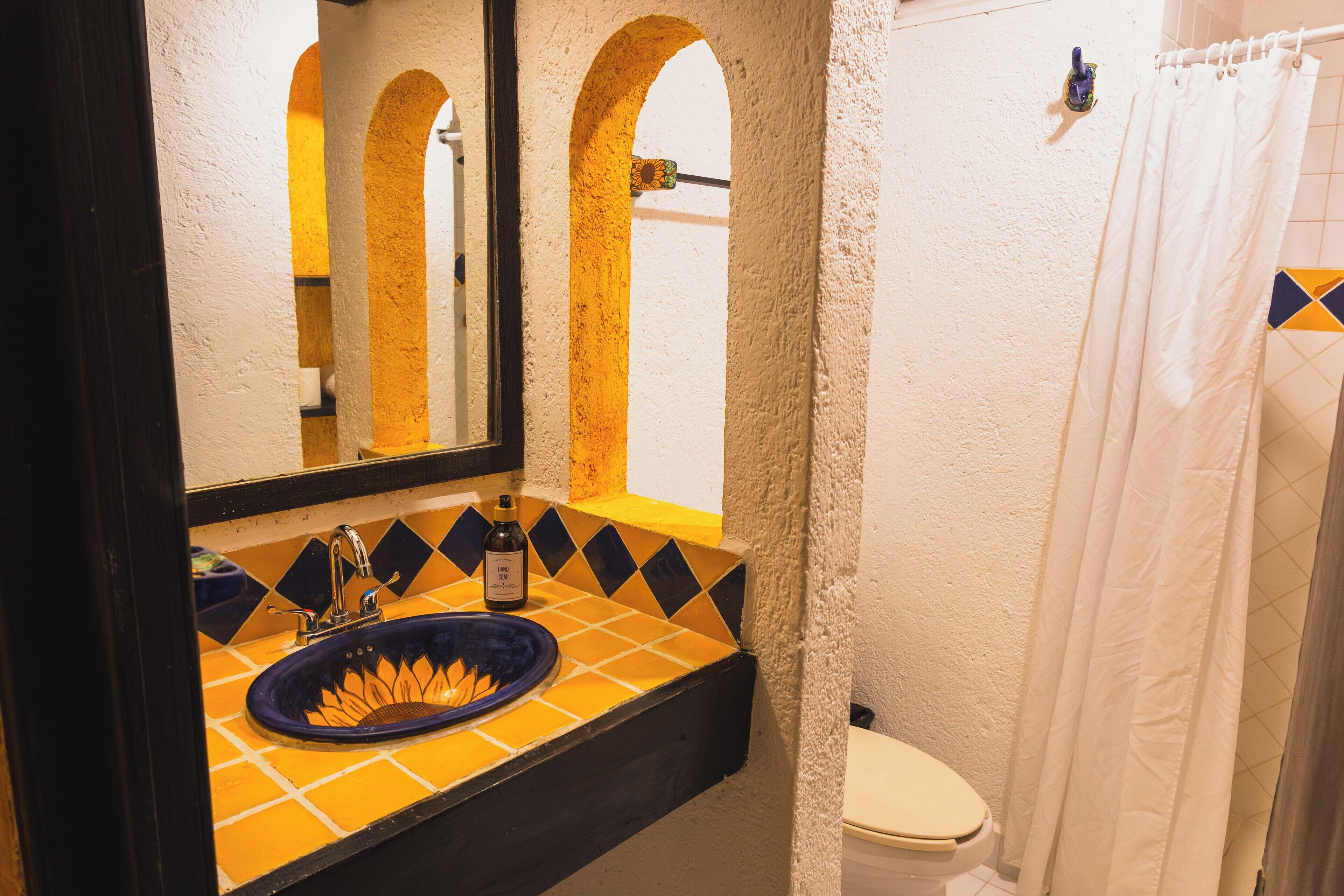 Un baño con lavabo, espejo e inodoro.