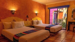 A hotel room with two beds, a balcony with a view, and a small table with a chair. - Hotel Hacienda Maria Bonita (Playa del Carmen)
