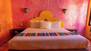 A bed with a headboard, pillows, and a colorful blanket. - Hotel Hacienda Maria Bonita (Playa del Carmen)