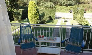 A balcony with two blue chairs and a small table with drinks and snacks. - Cozy Villa With a Fenced Garden (Lignano Sabbiadoro)