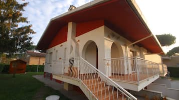 A building with a red roof, white walls, and a balcony with white railings.