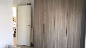A room with a large wardrobe, a radiator, and a door leading to another room. - Sicily house 100 mt from the sea, garden, climate, terrace, laundry room (Cervia)