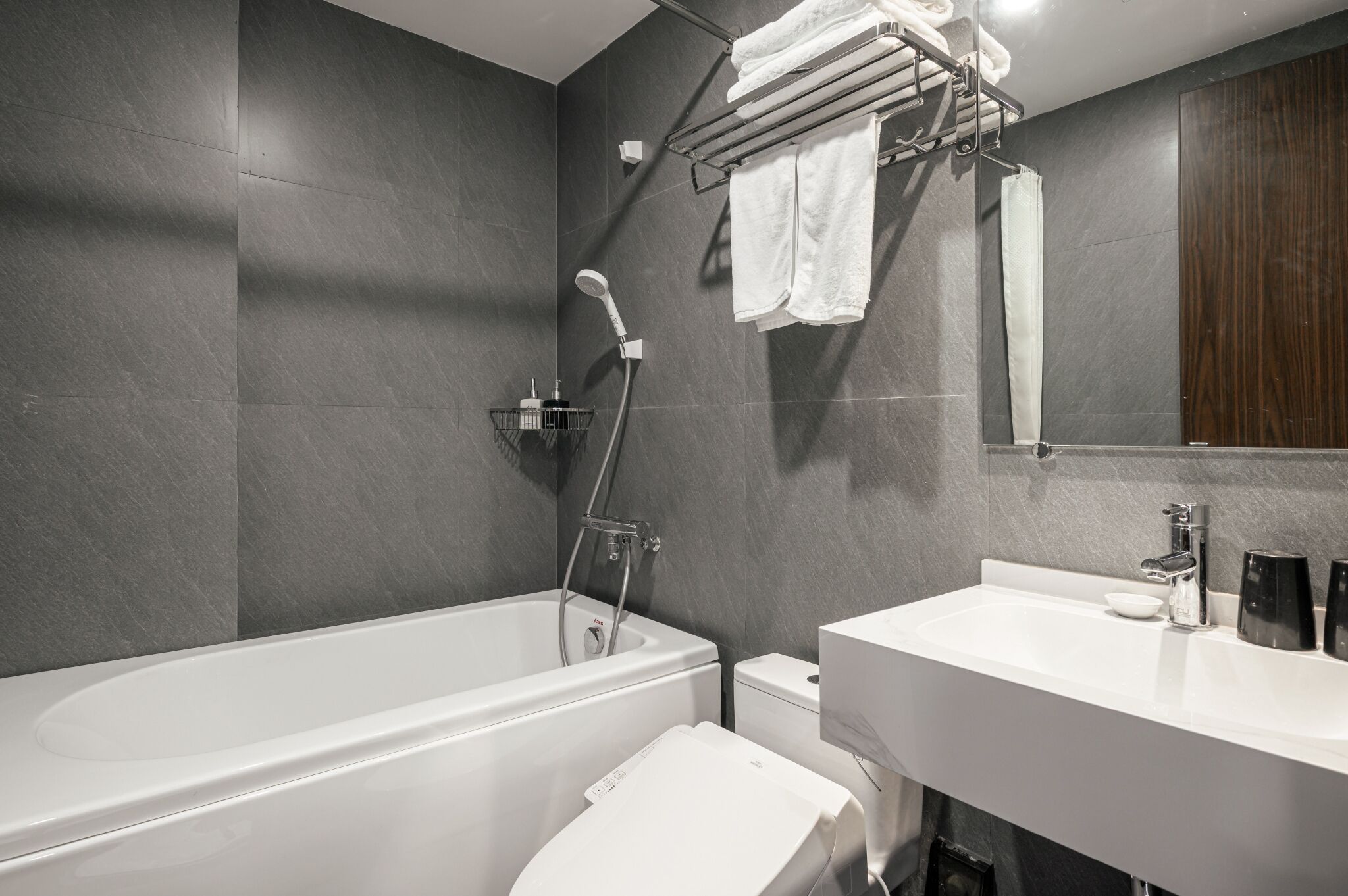A modern bathroom with a bathtub, toilet, and sink.