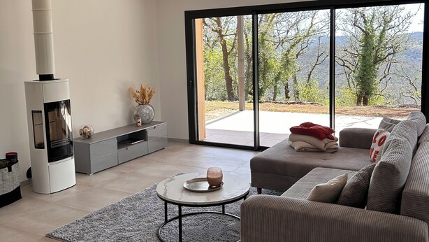 A modern living room with a fireplace, a sofa, a coffee table, and a view of the outdoors. - Recent house surrounded by a natural park (Saint-Jean-de-Laur)