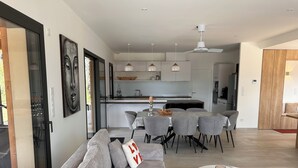 A modern living room with a sofa, a coffee table, and a dining area with chairs and a table. - Recent house surrounded by a natural park (Saint-Jean-de-Laur)