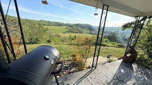 A patio with a barbecue grill, outdoor seating, and a view of a green landscape. - Wolf River Ridge on DHL 
1 minute from boat ramp! 
Kayaks & Bikes included (Byrdstown)