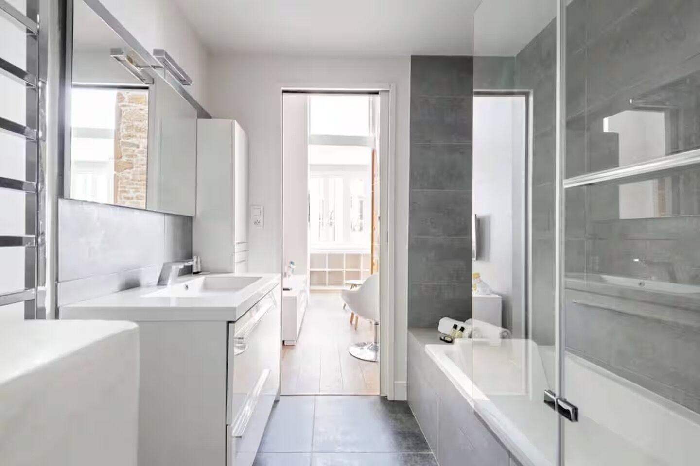 A modern bathroom with a large mirror, a bathtub, and a shower area.