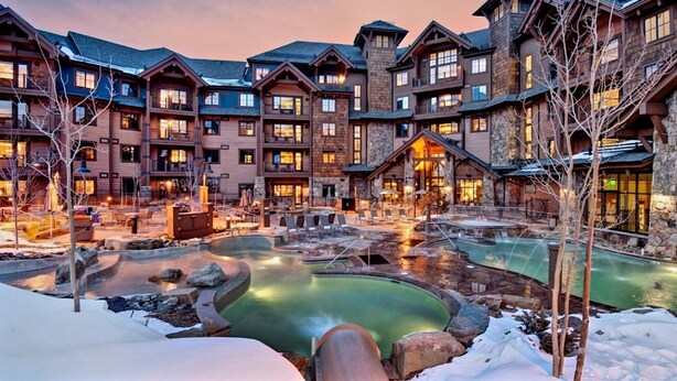 A resort with multiple buildings, a heated outdoor pool, and a snow-covered landscape. - Lux Slope-side 1BR.2BAw/FullKitchen, 1 King, 1 Queen Sofa  @ Grand Lodge Peak 7 (Breckenridge)