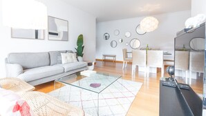 En moderne stue med sofa, sofabord og spiseplads.