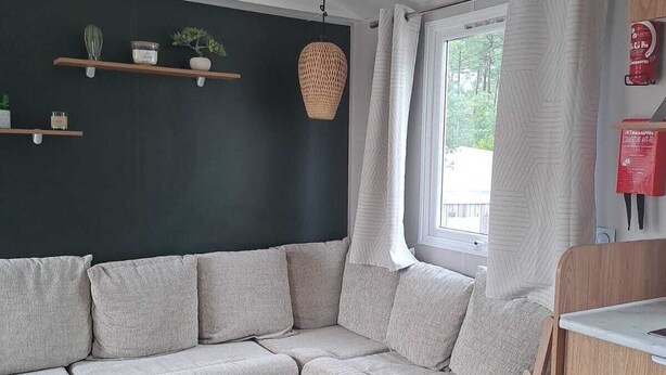 Moderni olohuone, jossa on kulmasohva, puinen sohvapöytä ja seinään upotetut puukaapit.