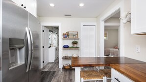 A modern kitchen with a stainless steel refrigerator, wooden countertop, and white cabinetry. - New Cottage within minutes from our Famous Springs! (Fort White)