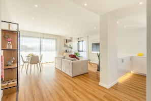 A modern apartment with a dining area, a living room with a sofa, and a kitchen. - Garajau Sea Side by Atlantic Holiday (Caniço)
