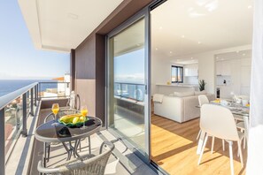 A modern apartment with a balcony, a dining area, and a kitchen. - Garajau Sea Side by Atlantic Holiday (Caniço)