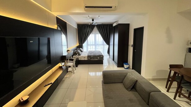 A modern living room with a flat-screen TV, a sofa, a dining table, and a bed.