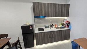 A compact kitchen with a refrigerator, sink, and countertop appliances.