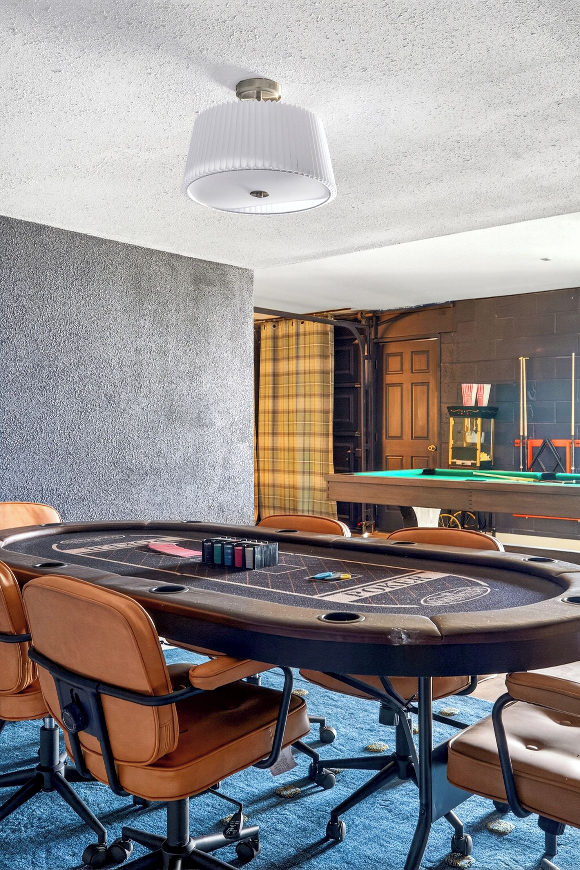 Une salle de conférence équipée d’une table de billard, de fauteuils en cuir et d’un luminaire au plafond.