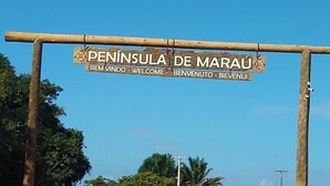 Un cartello di legno con la scritta "Peninsula de Maraú" e "BEM VINDO" per dare il benvenuto ai visitatori.