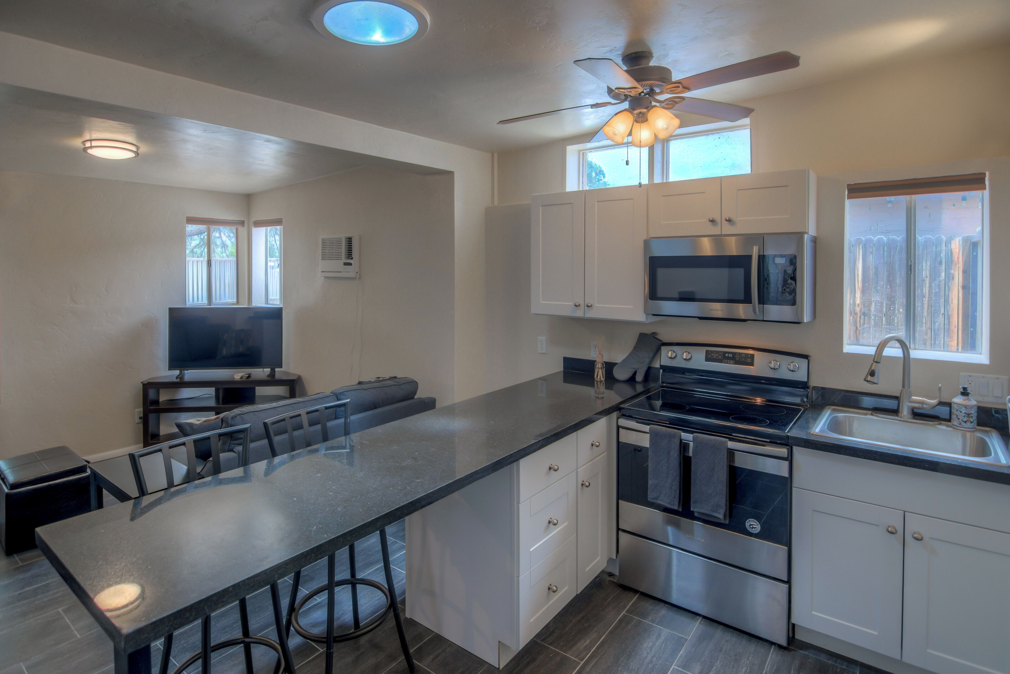 Una cocina moderna con una isla central, electrodomésticos de acero inoxidable y muebles de cocina blancos.