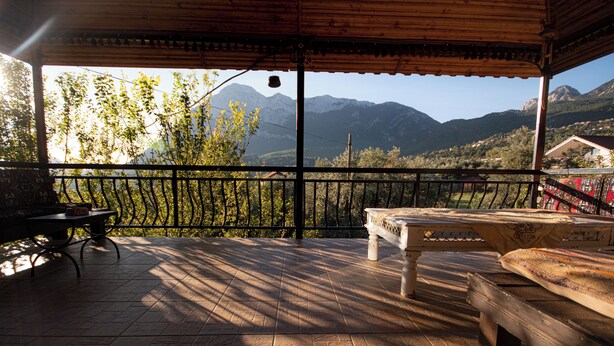 A covered outdoor seating area with a view of mountains.