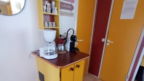 A compact kitchen with a yellow cabinet, a coffee maker, and a kettle. - Gorges du verdon M.H. Eden34 camping3*, swimming pool, in the middle of lavender fields (Sainte-Croix-du-Verdon)