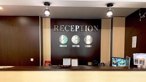 Un comptoir d’accueil avec des horloges indiquant l’heure de Londres, de Krasnoïarsk et de Moscou.