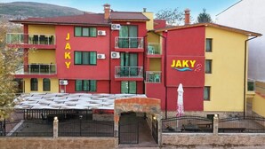 Un immeuble à plusieurs étages dont la façade porte l’inscription « JAKY ».