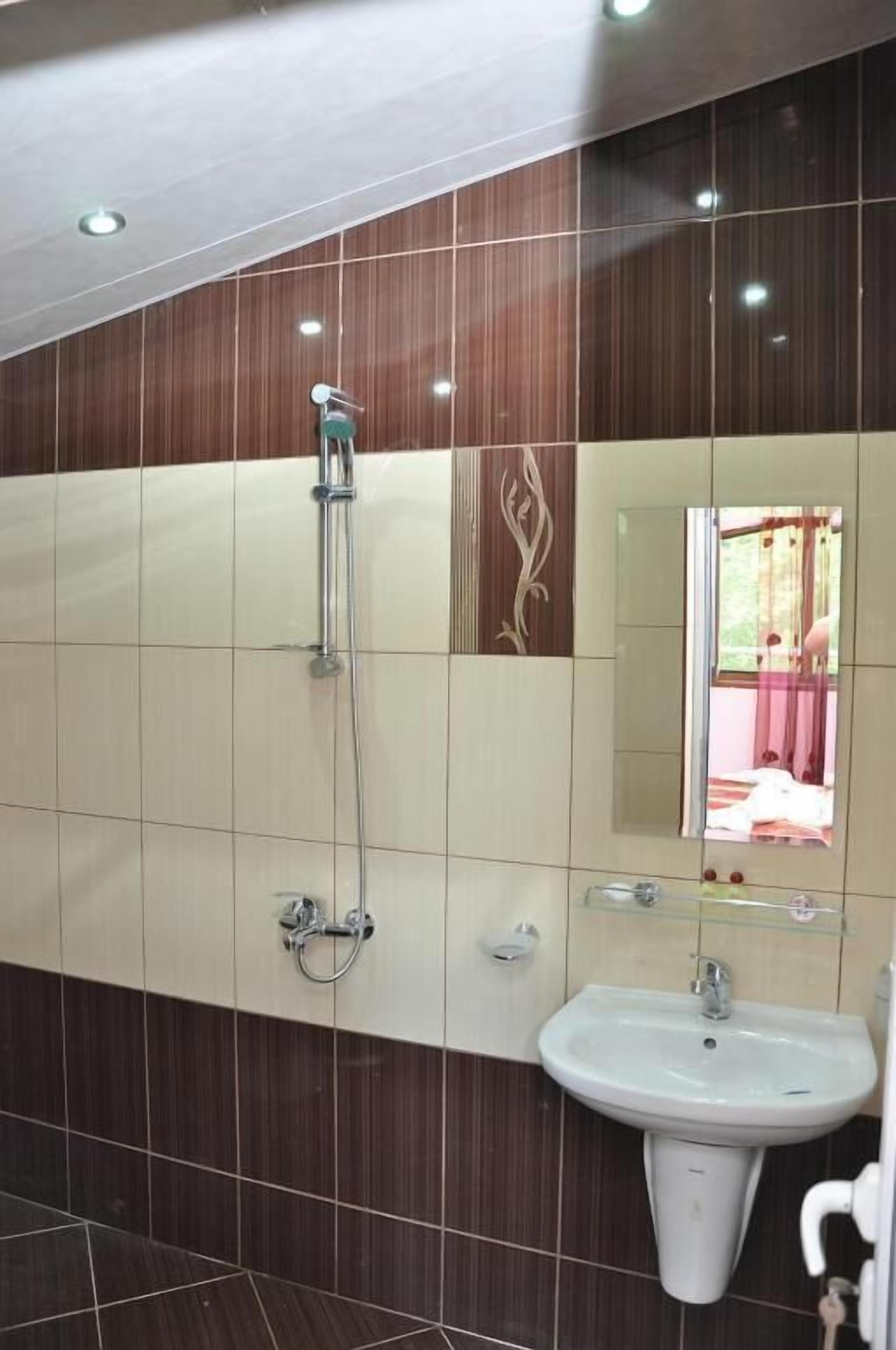 Un bagno con doccia, lavandino e specchio.