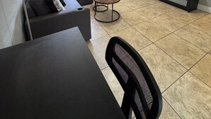 Una sala de estar con un sofá, una mesa de centro, un televisor y una mesa de comedor.