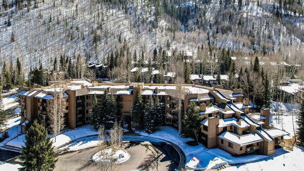 Ein Resort mit mehreren Gebäuden, einem zentralen Innenhof und bewaldeten Hügeln ringsherum.