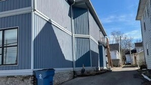 En tvåvåningsbyggnad med en grå fasad och en synlig garageport.