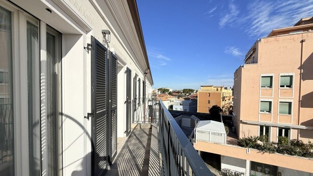 A balcony with a view of neighboring buildings, a metal railing, and a clear sky. - SE202 - Senigallia, new, fully equipped three-room apartment in the city center (Senigallia)