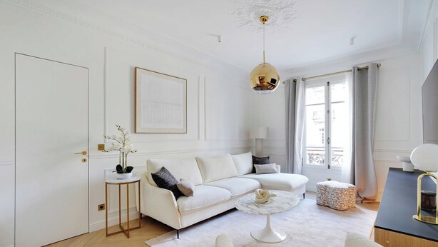 A modern living room with a white sofa, a round coffee table, and a pendant light. - Elegant A/C Apt 2br/6p - Paris 17th/monceau (Paris)