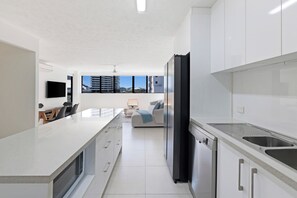 A modern kitchen with a large island, built-in appliances, and a view of the cityscape. - Stylish 2BDR Retreat in Broadbeach Sleeps 4 (Gold Coast)