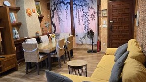 Ein Zimmer mit einer Couch, Stühlen, einem Tisch und einer Decke mit Wandmalerei.