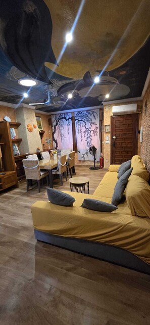 A room with a sofa, chairs, a table, and a ceiling with a mural. - Villa Noa. (Torrevieja)