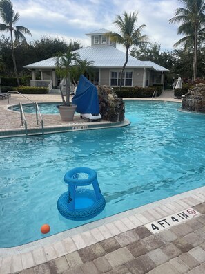 A swimming pool with a 4 ft 4 in depth marker, a covered planter, and a lifeguard stand. - Green links -Lely Resort 2 Bdrm, 2 bath condo (main floor with many amenities) (Naples)