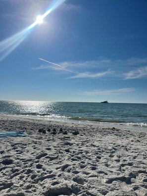 A beach with a sandy shore, a boat in the water, and a clear sky. - Green links -Lely Resort 2 Bdrm, 2 bath condo (main floor with many amenities) (Naples)