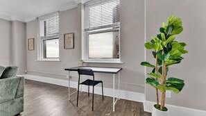 Een kamer met een bureau, stoel en een potplant.
