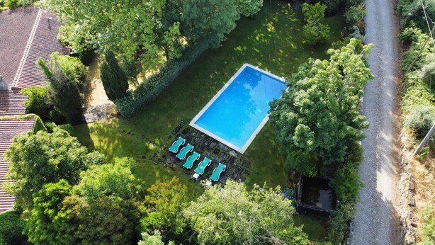 An aerial view of a rectangular swimming pool surrounded by lush greenery, with a stone pathway leading to a row of lounge chairs. - Fabulous farm in Mesquitela, Mangualde for vacation with pool for 18 people (Mesquitela)