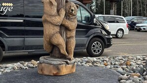A sculpture of bears on a wooden base in front of a building labeled "RESTIGE LODGE". - Four Points By Sheraton Prince George (Prince George)