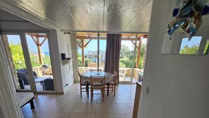 A spacious room with a large dining table, a bench, and a view of the outdoors. - House in the Marine di Sant'Ambroggio, 10-minute walk to the sea, large terrace (Lumio)
