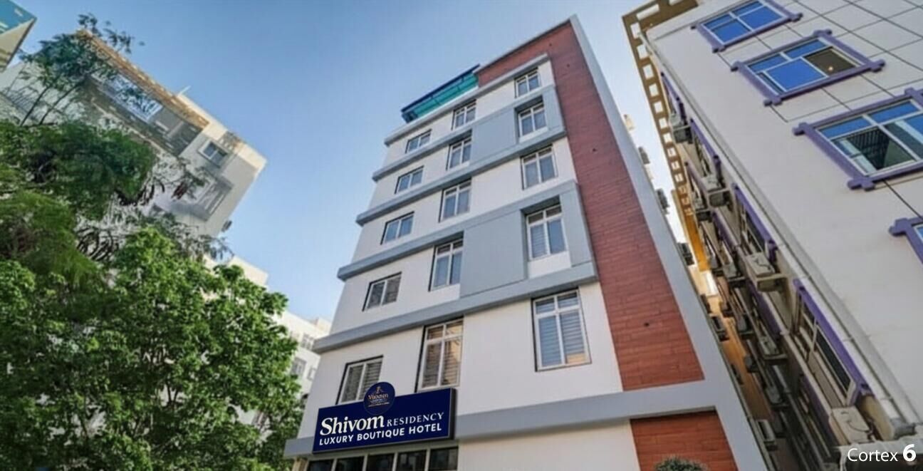 Un edificio de varios pisos con un cartel que indica Shivom Residency Luxury Boutique Hotel.